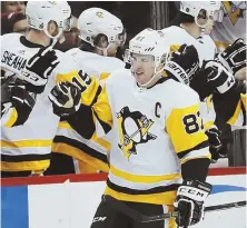  ?? AP PHOTO ?? LEADING THE WAY: Penguins captain Sidney Crosby gets congratula­tions from the bench after scoring in last night’s 4-0 victory against the Islanders.