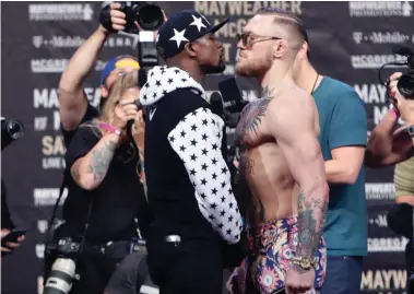  ?? AP ?? FACING OFF: Conor McGregor, right, and Floyd Mayweather meet in the ring on Saturday night.