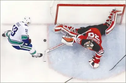  ?? The Associated Press ?? New Jersey Devils goalie Cory Schneider stretches out to stop a shot by Vancouver Canucks center Bo Horvat during third-period NHL action on Friday in Newark, N.J. The Canucks lost 3-2.