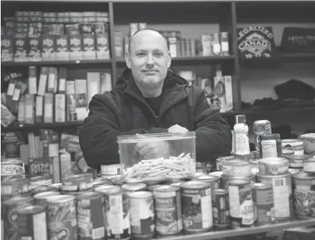  ?? DAX MELMER ?? Leo Lucier, owner of Compassion House, stands behind a container of rolled marijuana joints amid donated food collected Friday. Lucier, who was charged under the new federal Cannabis Act earlier this month, was giving out the pot in exchange for food and clothing for the needy.