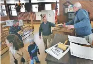  ?? AP FILE PHOTO/JIM COLE ?? Moderator Dick Kipperman, right, accepts a resident’s ballot during the 2008 annual town meeting in Springfiel­d, N.H.