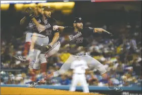  ?? AP/MARCIO JOSE SANCHEZ ?? In this multiple-exposure photo, Washington Nationals starting pitcher Stephen Strasburg throws to a Los Angeles Dodgers batter Friday during the third inning in Game 2 of a National League Division Series in Los Angeles.