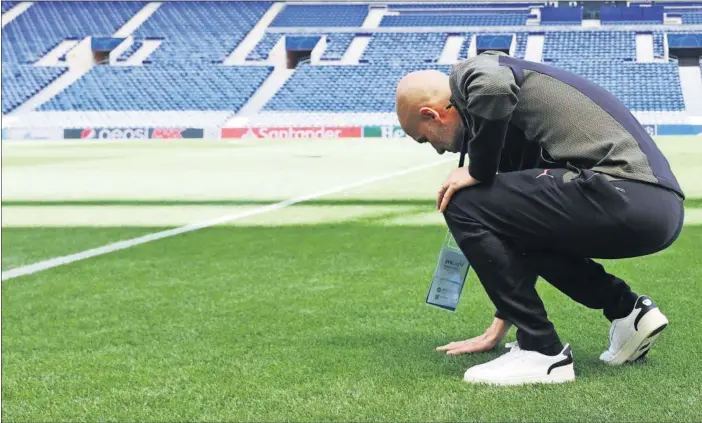  ??  ?? Guardiola toca comprueba el estado del césped del estadio de O Dragao antes el entrenamie­nto del Manchester City.