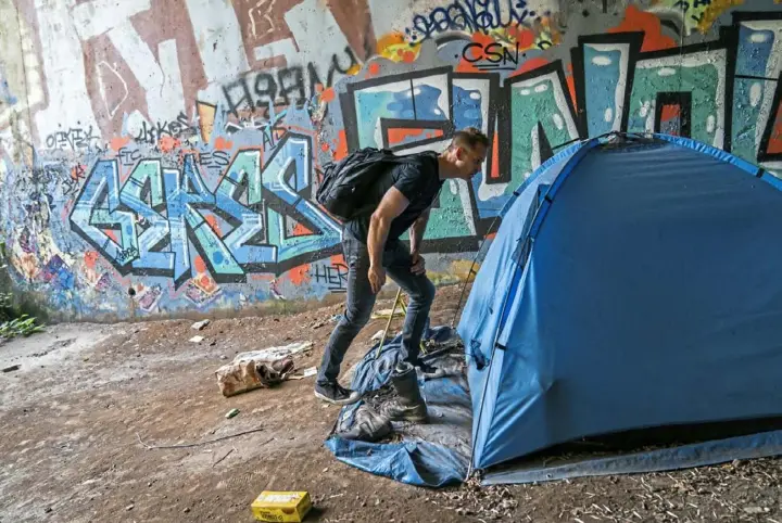  ?? Andrew Rush/Post-Gazette photos ?? Erik Wiesemann, who runs Light in My City, checks a tent for people as he delivers supplies to a homeless camp under a bridge on the South Side.