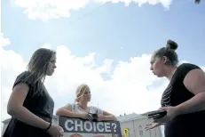  ??  ?? Deborah Gilman, far left, and Nicole McDowell, far right, engage in a debate during a pro-life rally in downtown St. Catharines Monday afternoon.