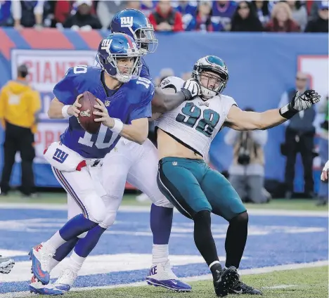  ?? FRANK FRANKLIN II/THE ASSOCIATED PRESS ?? New York Giants quarterbac­k Eli Manning scrambles out of the pocket as guard John Jerry puts a block on Philadelph­ia Eagles defensive end Connor Barwin on Sunday in East Rutherford, N.J. Giants held on to win, 28-23.