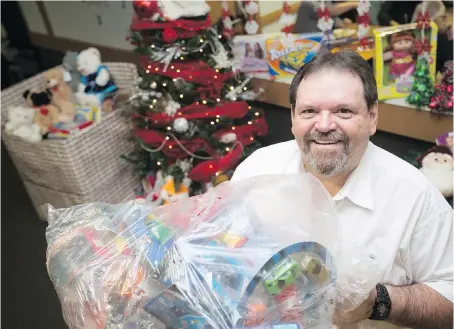  ?? DAX MELMER ?? Dan Batson, administra­tor at the Moose Lodge, holds a large bag of toys Thursday collected for the lodge’s Toys for Tots campaign. The need for Christmas toys is the highest he has seen in more than 25 years.