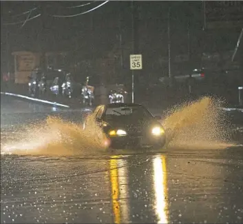  ?? Rebecca Droke/Post-Gazette ?? A car attempts to go through water pooling along Route 51 on Friday night south of Edgebrook Avenue. The National Weather Service issued a flash flood warning for Allegheny and other counties as heavy rain passed through the region.