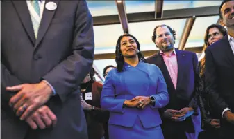  ?? Gabrielle Lurie / The Chronicle ?? San Francisco Mayor London Breed, who opposes Propositio­n C, and Salesforce CEO Marc Benioff, who has announced his support for it, listen to a speech last month at Salesforce East.