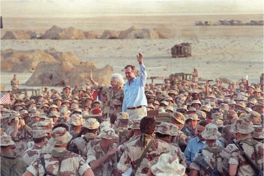  ?? (Rick Wilking/Reuters) ?? PRESIDENT GEORGE H. W. Bush waves goodbye to US Marines as they conclude a Thanksgivi­ng Day visit with troops in the Saudi desert in 1990.