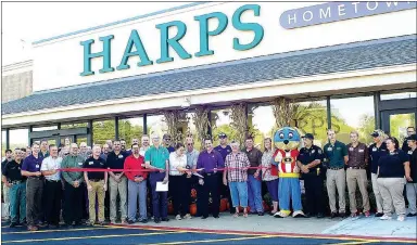  ?? Photo by Randy Moll ?? Gentry store manager Amber Parker cut the ribbon at the new Gentry Harps Food Store on Wednesday, Sept. 21. She was joined by Harps leaders and store employees, as well as city officials and members of the Gentry community, for the special event.