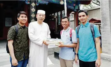  ??  ?? Imam Masjid Qianmen menerima sumbangan dua buah al-quran yang disampaika­n penasihat program, Muhammad Nazirul Mohd Noor, Mohd Aasim (kanan) dan timbalan pengarah program, Muhammad Hanif Naim (kiri).