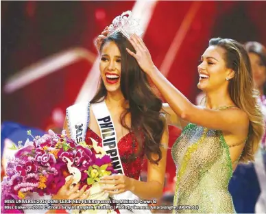  ??  ?? MISS UNIVERSE 2017 DEMI-LEIGH NEL-PETERS passes the Mikimoto Crown toMiss Universe 2018 Catriona Gray in Bangkok, Thailand (Photo by Gemunu Amarasingh­e/AP Photo)