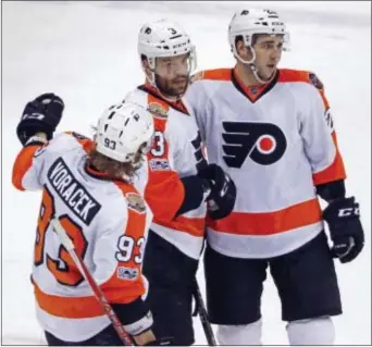  ?? GENE J. PUSKAR — THE ASSOCIATED PRESS ?? Philadelph­ia’s Radko Gudas (3) celebrates his empty-net goal with Jake Voracek (93) and Brandon Manning during the third period of Sunday’s game against the Penguins in Pittsburgh.