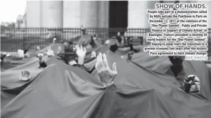  ??  ?? People take part in a demonstrat­ion called by NGOs outside the Pantheon in Paris on December 12, 2017 at the sidelines of the “One Planet Summit - Public and Private Finance in Support of Climate Action” in Boulogne. France’s president is hosting 50...