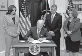  ?? Yuri Gripas/Abaca Press/TNS ?? President Joe Biden signs the executive order on access to reproducti­ve health care services in the Roosevelt Room at the White House on Friday. Behind Biden are, from left, Vice President Kamala Harris, HHS Secretary Xavier Becerra and Deputy Attorney General Lisa Monaco.