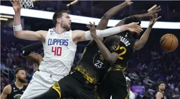  ?? AP/JEFF CHIU PHOTO ?? Los Angeles Clippers center Ivica Zubac (40) reaches for the ball next to Golden State Warriors forward Draymond Green (23) and forward Andrew Wiggins during the first half of an NBA basketball game in San Francisco, Wednesday, Nov▪ 23, 2022▪