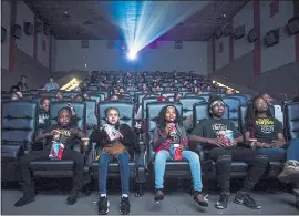  ?? JAKE MAY — THE FLINT JOURNAL-MLIVE.COM VIA AP ?? Mari Copeny, third from left, watches a free screening of the film “Black Panther” with more than 150 children, after she raised $16,000 to provide free tickets at an entire theater on Monday in Flint Township, Mich.