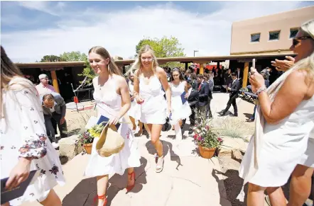  ??  ?? ABOVE: Graduates walk out Friday at the end of the Santa Fe Prep graduation. BELOW: Headmaster Jim Leonard watches as Jordan Mazur shows off her diploma Friday after receiving it during the Santa Fe Prep graduation. For more photos, visit...