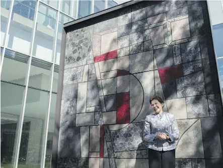  ?? SHAUGHN BUTTS ?? Ernestine Tahedl, the artist who created the nine mosaic panels that previously adorned the Canada Post building on the same site downtown, stands by the refurbishe­d and repurposed artwork outside the new Royal Alberta Museum Tuesday, where...