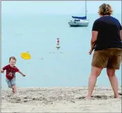  ?? SARAH GORDON/THE DAY ?? Luke Campbell, 3, throws a Frisbee as he plays with his mother, Kristin, at Crescent Beach on Tuesday in Niantic. They are from Portland, Ore., and visiting friends who live in the area. “Just because it’s foggy and not too warm doesn’t mean it’s not a...