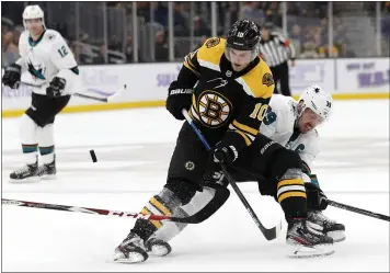 ?? WINSLOW TOWNSON — THE ASSOCIATED PRESS ?? Boston’s Anders Bjork, front, and the Sharks’ Logan Couture battle for a loose puck in the first period Tuesday.