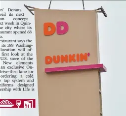  ?? STAFF PHOTO BY CHRIS CHRISTO ?? GETTING READY: Workers position a sign outside the new Dunkin’ Donuts concept store in Quincy, which opens next week.
