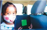  ?? MEGAN MARPLES/ CRONKITE NEWS VIA AP ?? Second-grader Winona Begaye uploads homework in her family’s vehicle in a dirt lot near Blue Gap, Ariz., on Sept. 25.