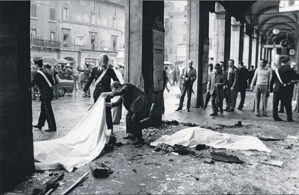  ?? MONDADORI / GETTY ?? Dos de las víctimas del atentado momentos después de la explosión en la plaza de la Loggia de Brescia, el 28 de mayo de 1974