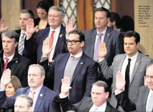  ?? Alex Brandon/AP ?? Rep. George Santos takes the oath of office. The fingers of his other hand were crossed.