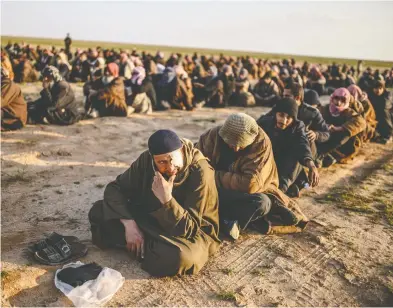  ?? BULENT KILIC / AFP / GETTY IMAGES FILES ?? Men suspected of being Islamic State fighters wait to be searched by members of the Kurdish-led Syrian Democratic
Forces (SDF) in February after leaving the ISIL group’s last holdout of Baghouz, Syria.