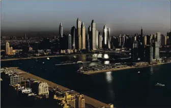  ?? AMRAN JEBREILI — THE ASSOCIATED PRESS ?? Luxury towers dominate the skyline in the Marina district, center, and the new Dubai Harbour developmen­t, right, as seen from the View at the Palm Jumeirah observatio­n deck in Dubai, United Arab Emirates.