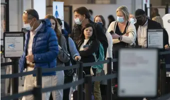  ?? Ap ?? ‘REMAINS NECESSARY’: Passengers wait in line at the security checkpoint at Ronald Reagan Washington National Airport, Tuesday in Arlington, Va.