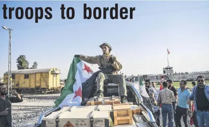  ?? PHOTO: ABACA PRESS/TNS ?? Raising a flag . . . Fighters of the Turkishbac­ked Free Syrian Army, a rebel group supported by Turkey, enter Tal Abyad town, after it was cleared of Syrian Kurdish YPG militia, which Turkey regards as a terror group, in Turkey’s Operation Peace Spring, yesterday.