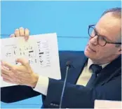  ?? NG HAN GUAN/AP ?? Peter Ben Embarek of the WHO team holds up a chart showing pathways of transmissi­on of the virus during a joint news conference in February in China.