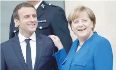  ?? — AFP ?? German Chancellor Angela Merkel (R) and French President Emmanuel Macron leave the Elysee Palace in Paris on Thursday, after an annual Franco-German Summit.