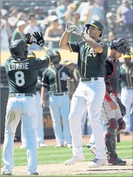  ?? MARCIO JOSE SANCHEZ — THE ASSOCIATED PRESS ?? The A’s’ Matt Olson, front right, celebrates his two-run, eighth-inning home run with teammate Jed Lowrie — one of three homers the team hit in Saturday’s win over Cleveland.