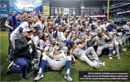  ?? JON DURR-USA TODAY SPORTS ?? THE LOS ANGELES DODGERS pose for a group photo after their win over the Milwaukee Brewers in game seven of the 2018 NLCS playoff baseball series at Miller Park Stadium.