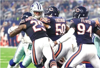  ?? | RON JENKINS/ AP ?? Cowboys quarterbac­k Dak Prescott sneaks in for a touchdown against the Bears’ Harold Jones- Quartey, Jerrell Freeman and Leonard Floyd in the first quarter Sunday in Arlington, Texas.