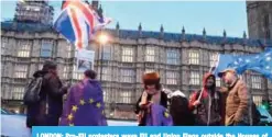  ?? —AFP ?? LONDON: Pro-EU protesters wave EU and Union Flags outside the Houses of Parliament in central London as Britain’s Prime Minister Theresa May makes a statement to the House on the phase one Brexit interim agreement with the EU.