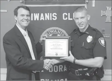  ?? News-Times/Michael Orrell ?? Officer of the month: El Dorado Kiwanian Jeffrey Sawyer, left, presents El Dorado Police Officer Gerid Alan Ardwin with a certificat­e of appreciati­on on Wednesday for being named Kiwanis’ Officer of the Month for July during their noon meeting in the...