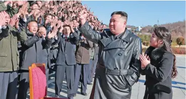  ?? (AFP) ?? This undated picture released from KCNA on Sunday shows North Korea’s leader Kim Jong Un and his daughter greeting scientists and engineers from a defence science research institute, and workers at a munitions factory, who contribute­d to the test-firing of the new interconti­nental ballistic missile