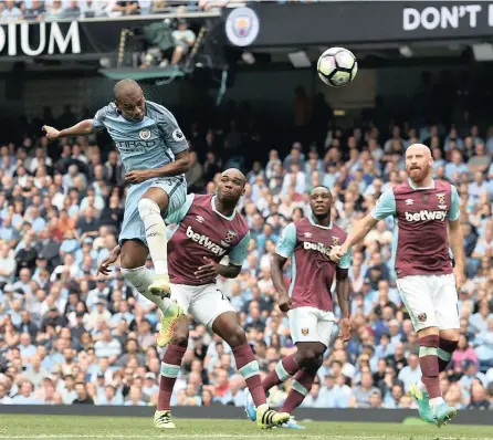  ?? PICTURE: EPA ?? HEADS UP: Manchester City’s Fernandinh­o, left, scores his side’s second goal in their 3-1 win over West Ham yesterday. City are now top of the log after three games of the reign of Pep Guardiola.