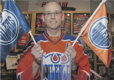  ?? SHAUGHN BUTTS ?? Ken Cookson, one of the co-owners of proamsport­s.ca, holds a pair of car flags on Tuesday. They’re hot sellers: “Our phones are off the hook and people are chomping at the bit,” Cookson says.