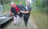  ?? [BRETT COOMER/HOUSTON CHRONICLE VIA AP] ?? Fred Stewart, left, is helped to high ground by Splendora Police officer Mike Jones after he was rescued from his flooded neighborho­od as rains from Tropical Depression Imelda inundated the area, Thursday in Splendora, Texas.