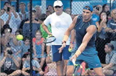  ??  ?? PUESTA A PUNTO. Nadal entrena en Brisbane ante la mirada de Toni y la de multitud de aficionado­s.