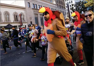  ?? PHOTOS BY DAI SUGANO — STAFF PHOTOGRAPH­ER ?? Runners, many wearing turkey costumes, race in the Silicon Valley Turkey Trot on Thursday in San Jose.