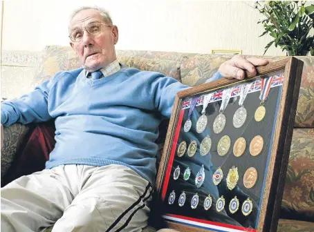 ?? Picture: Paul Reid. ?? “An amazing man”: Mr Coogan at home in Carnoustie with some of his medals.