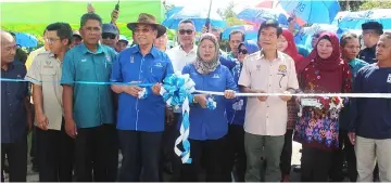  ??  ?? Wan Junaidi (fourth left) together with Jamilah (fourth right) perform a symbolic ceremony to declare open the bridge.