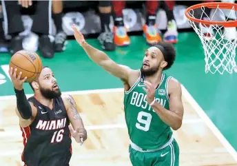  ?? AP PHOTO ?? Miami Heat forward Caleb Martin, left, shoots as Boston Celtics guard Derrick White defends during the first half in Game 5 of an NBA basketball Eastern Conference Final series Thursday, May 25, 2023, in Boston.
